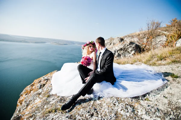 Charmig brud i en krans och eleganta brudgummen på landskapen i mo — Stockfoto