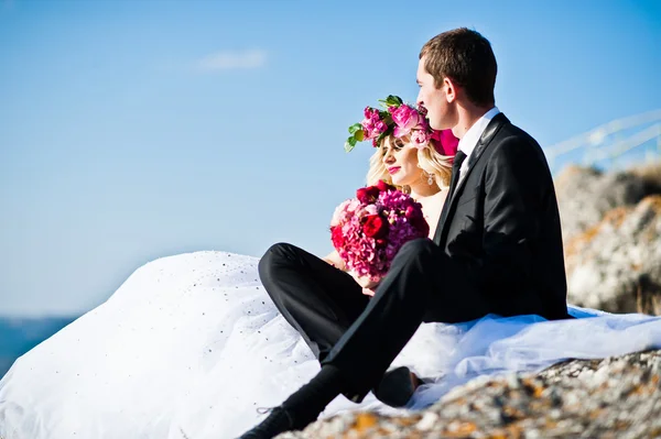 Charmig brud i en krans och eleganta brudgummen på landskapen i mo — Stockfoto