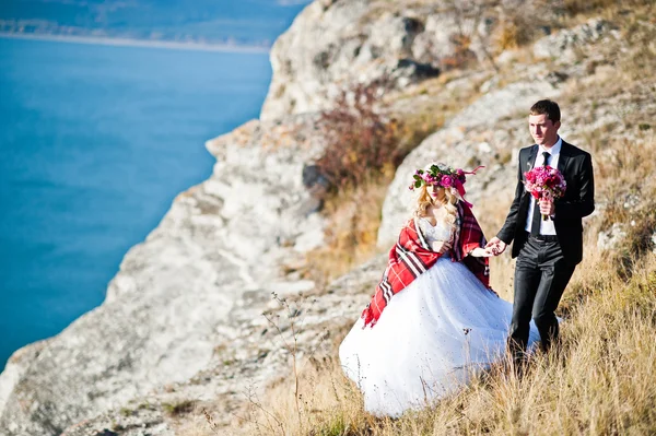 Encantadora novia en una corona y elegante novio en paisajes de mo —  Fotos de Stock