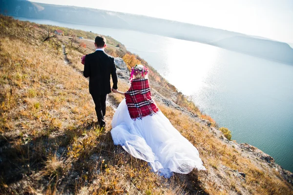 Charmig brud i en krans och eleganta brudgummen på landskapen i mo — Stockfoto