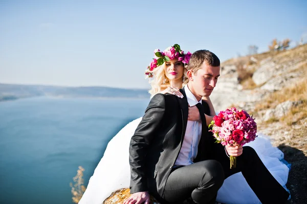 Charmig brud i en krans och eleganta brudgummen på landskapen i mo — Stockfoto