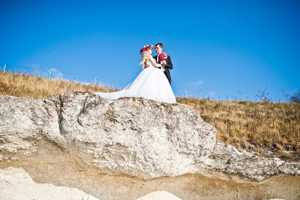 Charmig brud i en krans och eleganta brudgummen på landskapen i mo — Stockfoto