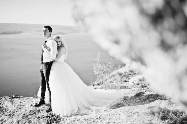 Charming bride and elegant groom on landscapes of mountains, wat — Zdjęcie stockowe