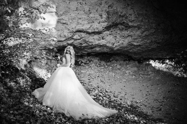 Affascinante sposa bionda su paesaggi di montagne, vicino grotta arguzia — Foto Stock