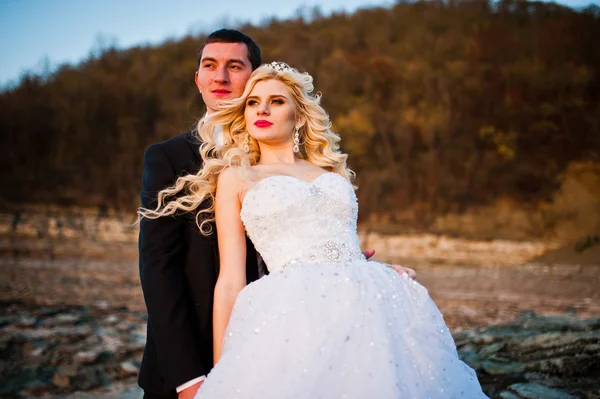 Charmante bruid en elegante bruidegom op landschap van bergen en — Stockfoto