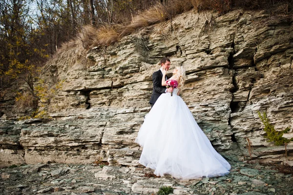 Encantadora novia y elegante novio en paisajes de montañas y — Foto de Stock