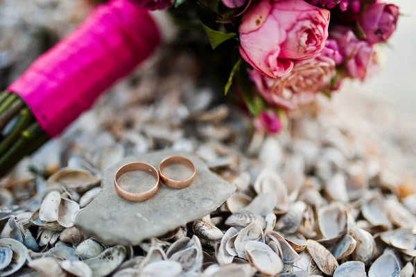 Elegant pink wedding bouquet with rings at shells — Stock Photo, Image