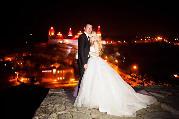 Gorgeous wedding couple background night city with castle in lig