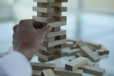 İnsan eli Jenga oyununun detaylarını parlak ofiste çıkarıyor.