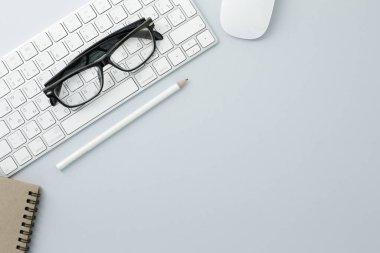 Gözlükler beyaz fare kalem beyaz klavye ve beyaz arkaplanda not defteri