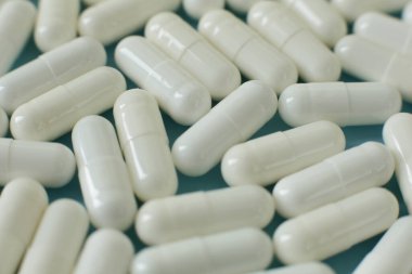 Mavi arka planda beyaz tıbbi haplar