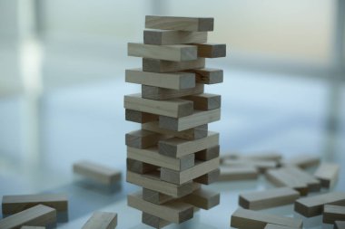 El, masa oyunu. Ofisteki cam bir masada tahta parmaklıklar.