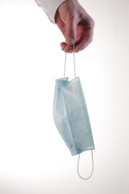 El ele tutuşmanın yakın plan tıbbi koruma maskesi.