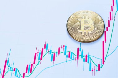 Bitcoin 'in altın sikkesi kripto para birimi ve kripto para değerlerindeki değişimler ofisindeki ahşap bir masada yatıyor.