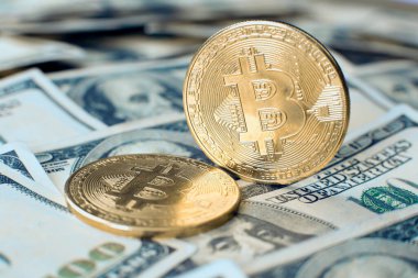 Altın bitcoin kripto para kendi ucunda duruyor, ikincisi yüz dolarlık banknotların üzerinde.