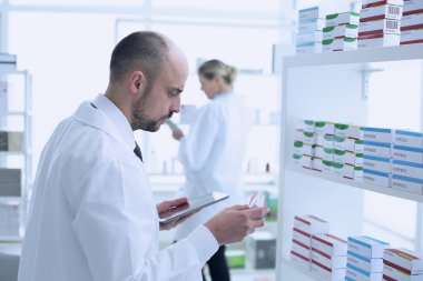 Eczacılar çalışıyor. Erkek ve Kadın. Özel üniforma giyen insanlar. Eczaneye yerleştirilen insanlar.