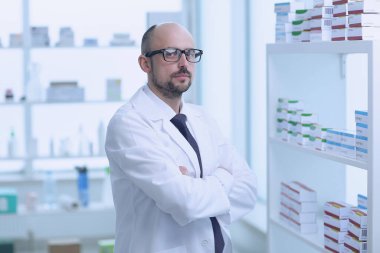 Eczacı çalışıyor. Eczanede özel sağlık üniforması giyen bir adam var..