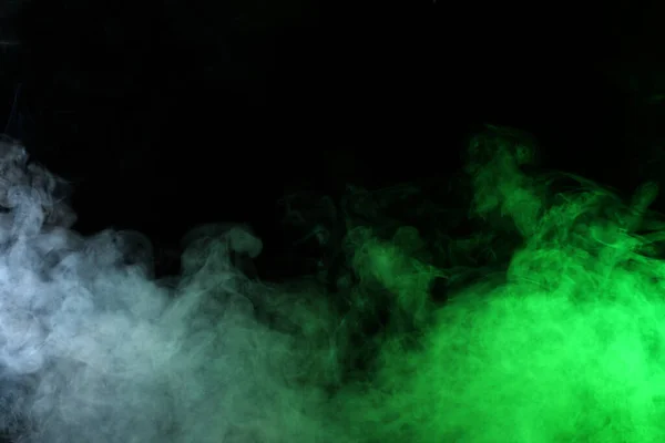 Humo en luz rojo-verde sobre fondo negro en oscuridad — Foto de Stock