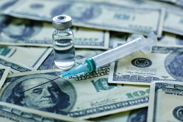 Vaccine vial and syringe on the background of one hundred dollar bills — Stock Photo, Image