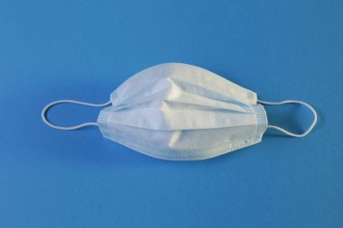 Mavi arka planda bir koruyucu tıbbi maske