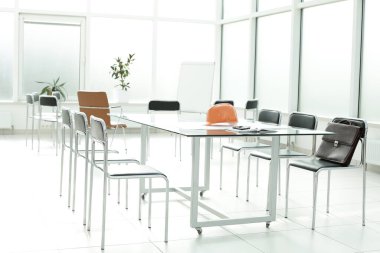 Flipchart inşaat başlığı sandalyeler evrak çantası telefon sapı cam masa parlak ofis alanı