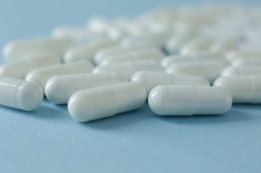 Mavi arka planda beyaz haplar. Kapat.