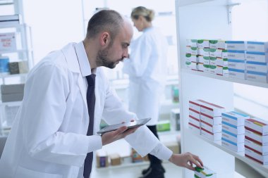 Eczacılar çalışıyor. Erkek ve Kadın. Özel tıp üniforması giyen insanlar. Eczaneye yerleştirilen insanlar.