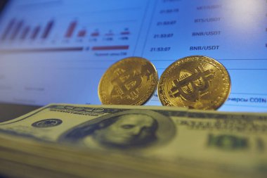 Laptop panelinde iki altın para ve bir yığın yüzlük banknot var..