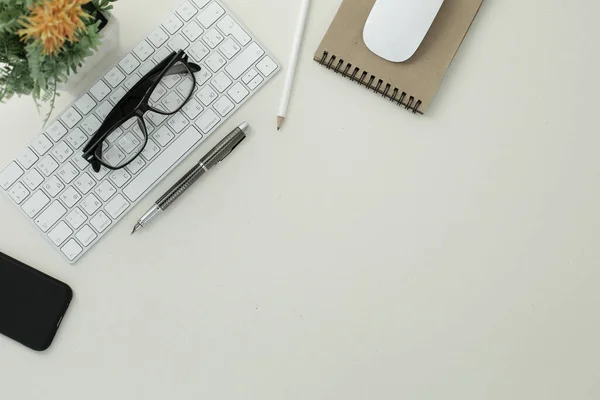 Beyaz klavye fare gözlüğü kalem kalem kalem telefon çiçeği beyaz arkaplanda bir tencerede