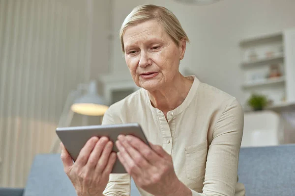 Senior woman using digital tablet at home. The use of technology by the elderly. — Stock Photo, Image
