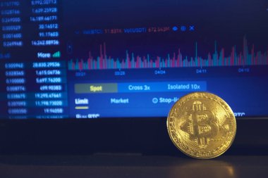 Laptop panelinde altın bir bitcoin var. Şifreleme kurlarını değiştirme sayfası dizüstü bilgisayarın ekranında açık.