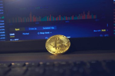 Laptop panelinde altın bir bitcoin var. Şifreleme kurlarını değiştirme sayfası dizüstü bilgisayarın ekranında açık.