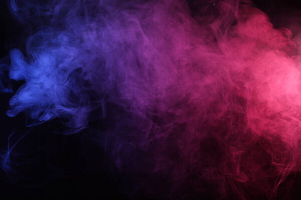 Smoke in red-blue light on black background in darkness