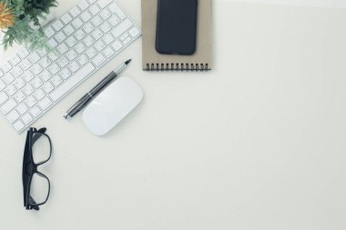 Beyaz klavye fare gözlüğü kalem kalem telefon çiçeği beyaz arkaplanda saksıda