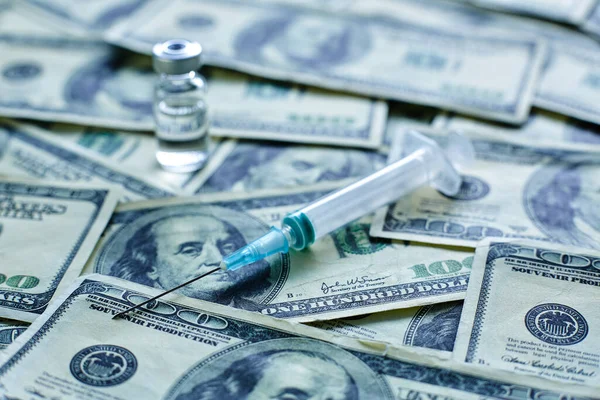 Vaccine vial and syringe on the background of one hundred dollar bills — Stock Photo, Image