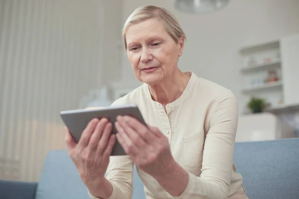 Senior woman using digital tablet at home. The use of technology by the elderly. — Stock Photo, Image