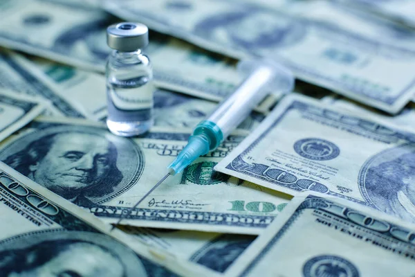 Vaccine vial and syringe on the background of one hundred dollar bills — Stock Photo, Image