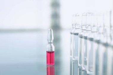 Vaccine vials on glass table in doctors office. Close up clipart