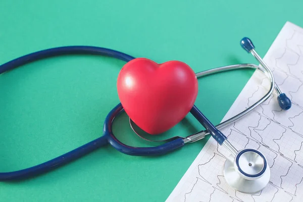 Estetoscopio cardiográfico y corazón sobre fondo verde — Foto de Stock