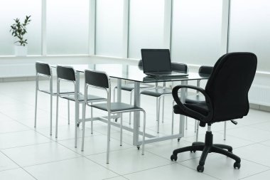 Ofisteki cam masada dizüstü bilgisayar.