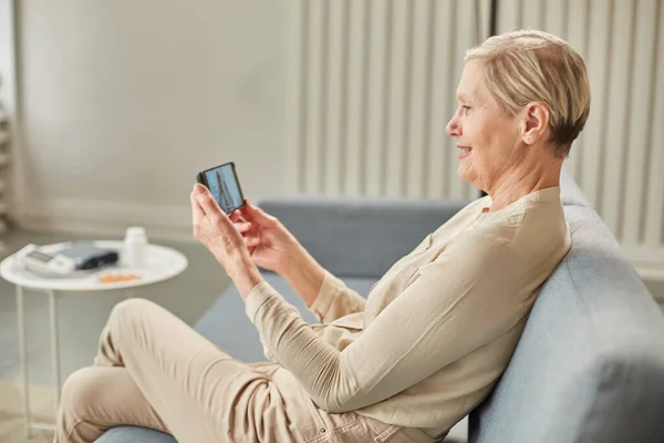 Sick woman during a video call with a doctor. Side view of patient talking during conference call with his doctor while at home during quarantine