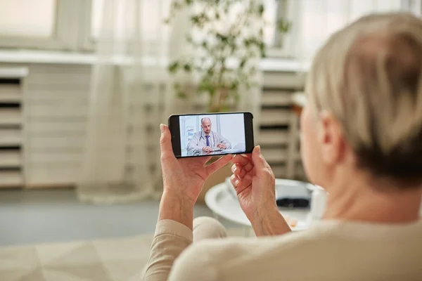 Sick woman during a video call with a doctor. Side view of patient talking during conference call with his doctor while at home during quarantine