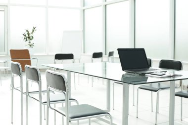 Flipchart dizüstü koltuklar cam masa parlak bir ofis alanı