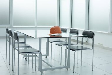 Ofisteki cam masanın üzerine miğfer.