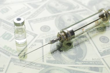 Cam şırınga ve şırınga, Amerikan dolarlarının arka planına karşı aşılarla dolu.