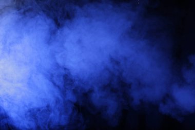 Yapay sihirli mavi ışık koyu arkaplandaki dumanı aydınlatıyor