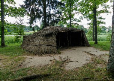 Straw canopy in the open air. A mysterious place where both humans and animals can hide. Renovated tent from the Iron Age. Around the trees. A magical place in the middle of the forest.