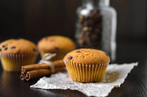 Closeup muffins met koffie pot en kaneel op donkere achtergrond — Stockfoto