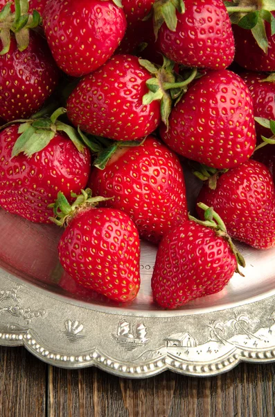 Verse aardbeien op vitage plaat, houten achtergrond — Stockfoto