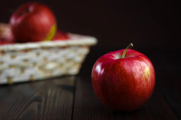 Μήλα σε ένα καλάθι σε ξύλινα φόντο — Φωτογραφία Αρχείου